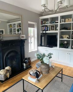 a living room filled with furniture and a fire place in front of a tv mounted on a wall