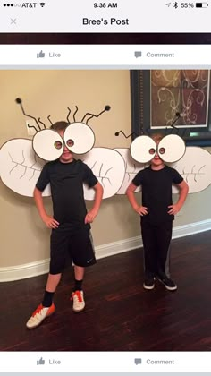 two children standing next to each other wearing paper masks