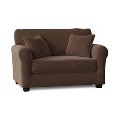 a brown couch with two pillows on it and one pillow in the middle of the sofa