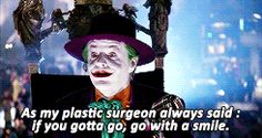 the joker is wearing a purple hat and green tie with words on it that read as my plastic surgeon always sold if you got go, go with a smile