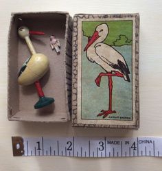 an old matchbox with a stork in it