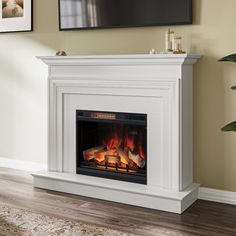 a white fireplace with an electric fire in the center and a flat screen tv above it