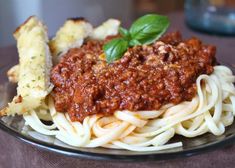 a plate of spaghetti with basil and garlic bread