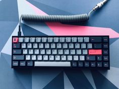 a black keyboard with red and white keys sitting on top of a blue tablecloth