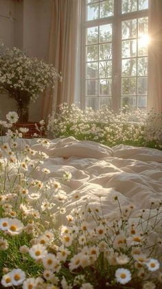 the sun shines through an open window onto a bed with white daisies