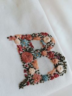 a close up of a piece of cloth with flowers on it and the letter d