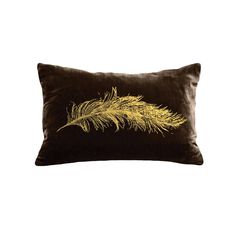 a black and gold pillow with a feather on it's back, against a white background