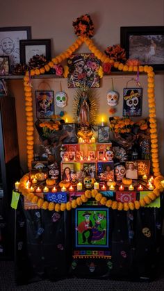 a shrine with candles and pictures on the wall above it, decorated with decorations for halloween