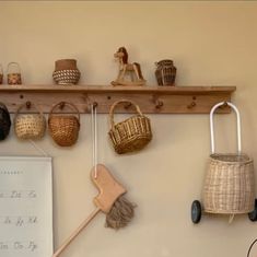 a shelf with baskets and brooms hanging on it