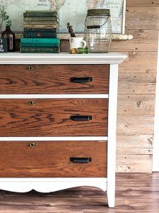 a white dresser with drawers and books on top