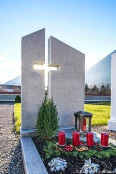 a grave with candles and a cross on it