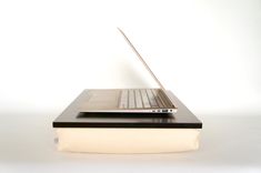 an open laptop computer sitting on top of a book