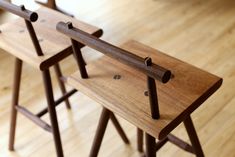 three wooden stools sitting on top of a hard wood floor next to each other