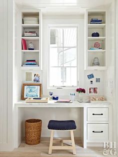 a white desk and chair in a small room with open shelvings on the wall