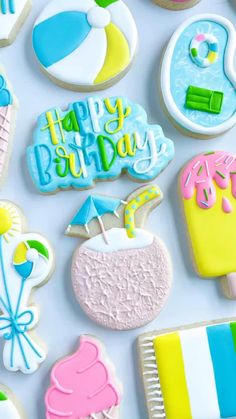 some decorated cookies are laying on a table with the words happy birthday written in frosting