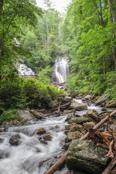 a small waterfall in the middle of a forest