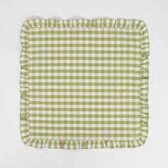 a green and white checkered pillow with ruffled edges