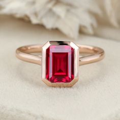 Experience the radiance of red with our Emerald Cut Lab Grown Ruby Engagement Ring in rose gold, a perfect solitaire choice for July birthstone enthusiasts. Luxury Timeless Ruby Ring With Bezel Setting, Red Ruby Solitaire Rings, Modern Ruby Engagement Ring, Ruby Bezel Engagement Ring, Red Ruby Ring In 14k Gold With Bezel Setting, Rose Gold Emerald Cut Gemstone Birthstone Ring, Red Ruby Ring In 14k Rose Gold, Rose Gold Ruby Ring With Lab-created Gemstone, Rose Gold Emerald Cut Birthstone Ring