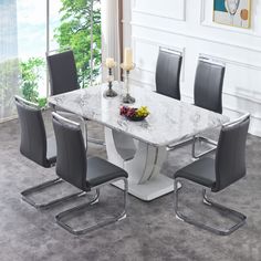 a white marble dining table surrounded by black chairs