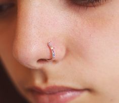 a close up of a woman's nose with a piercing in the middle of her nose