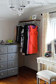 an image of a closet with clothes hanging on the rack and other items in it