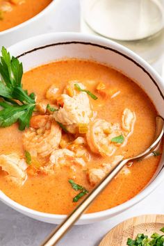 two bowls filled with soup and garnished with parsley