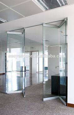 an empty office with glass walls and doors