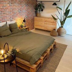 a bedroom with brick walls and wooden pallets on the floor, along with a large bed