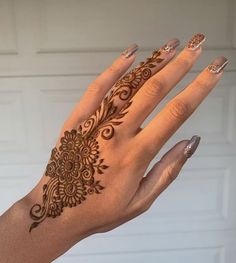 a woman's hand with henna tattoos on it