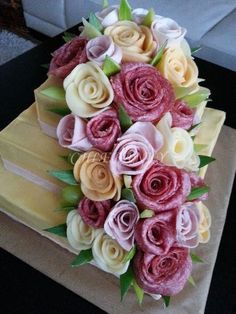 a bouquet of flowers is sitting on top of a cake that looks like it has been made out of paper