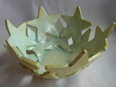 a green bowl sitting on top of a white table