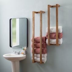 two towels are hanging on the wall next to a sink and mirror in a bathroom