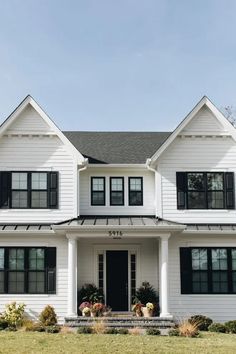 a large white house with black shutters and windows