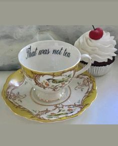 two cupcakes and a saucer with writing on them sitting next to each other