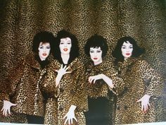 three women in leopard print outfits posing for the camera