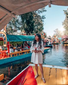 a woman standing on top of a boat in the water