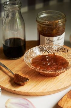 a wooden cutting board topped with jam on top of a table