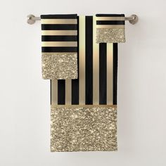 black, gold and white striped towel hanging on the wall