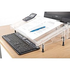 a laptop computer sitting on top of a wooden desk next to a keyboard and calculator