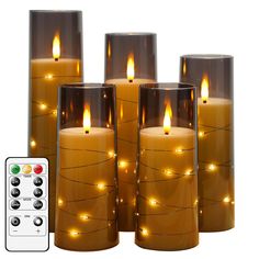 lighted candles with remote controls on white background