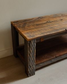 a wooden coffee table sitting on top of a hard wood floor next to a white wall