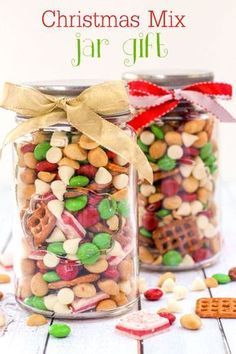 two jars filled with christmas mix sitting on top of a table