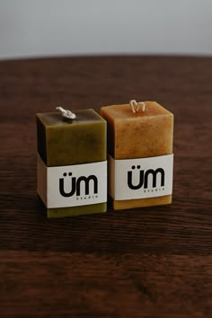 two soap bars sitting next to each other on a wooden table with the word um in front of them