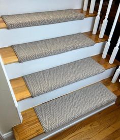 a set of stairs with carpeted treads and wooden handrails