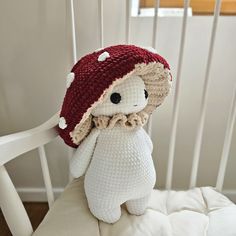 a crocheted teddy bear wearing a red and white hat on top of a chair