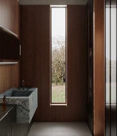 a bathroom with marble counter tops and wooden walls, along with an open door leading to the outside