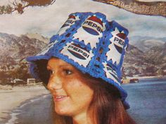 a woman wearing a blue hat with pepsi on it and mountains in the back ground