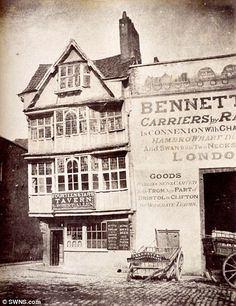 an old black and white photo of a car parked in front of a building