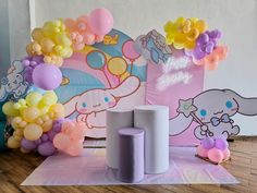 there are many balloons and decorations on the floor in front of this wall, including an elephant balloon arch