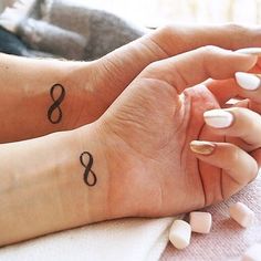 two people with matching tattoos on their hands